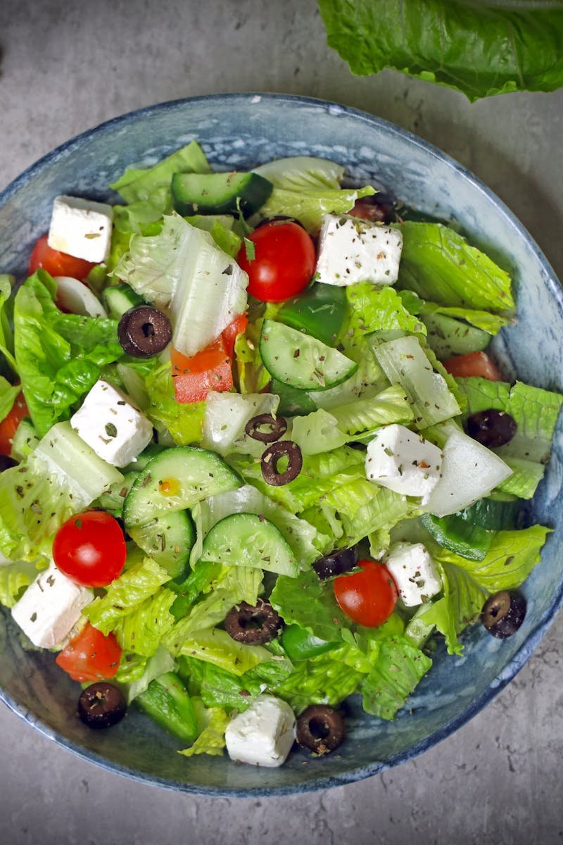 Top-down view of a vibrant Greek salad with fresh vegetables and feta cheese.